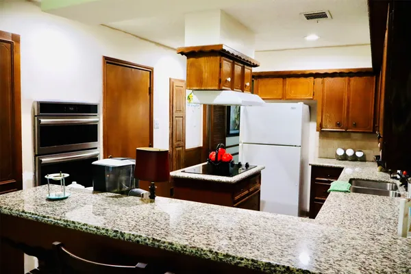 a kitchen with sink refrigerator and stove