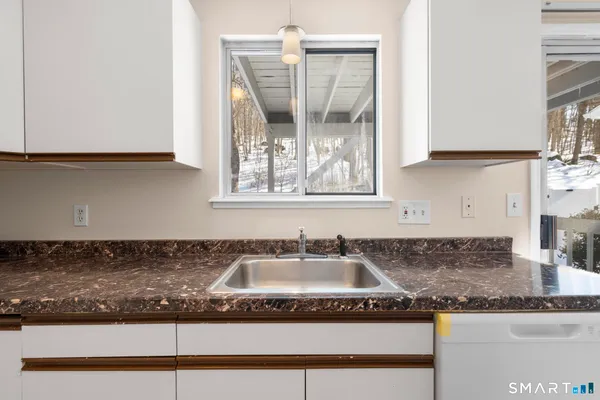 a kitchen with granite countertop a sink and a stove