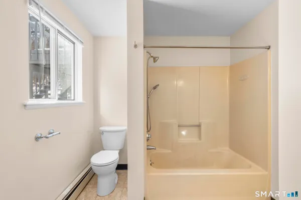 a bathroom with a toilet and a shower