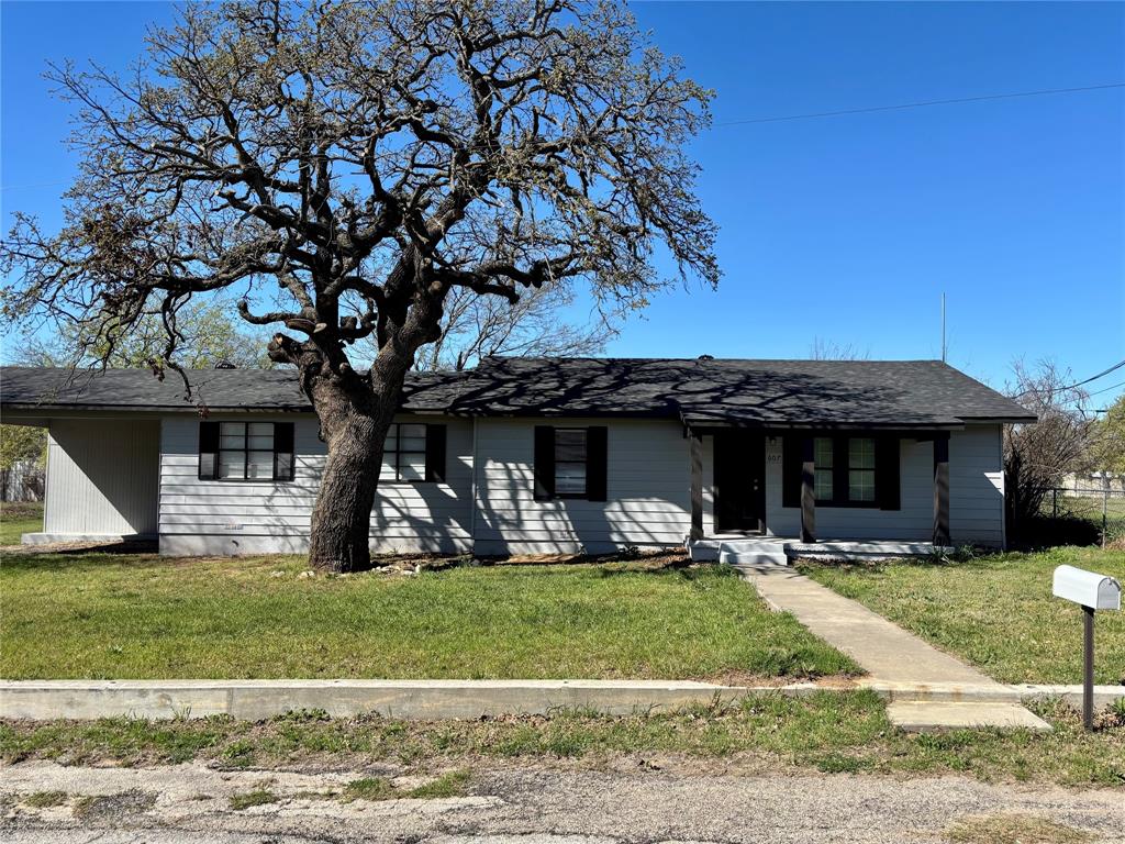 607 Baylor Street Nocona, TX 76255 - Photo 1 of 17 a front view of a house with garden