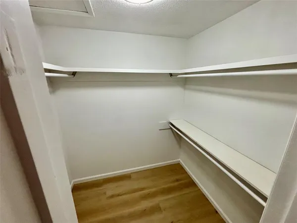 a view of walk in closet with empty racks