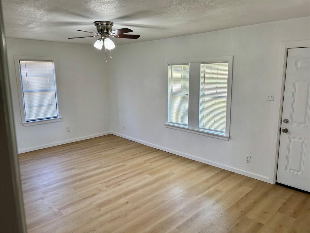 607 Baylor Street Nocona, TX 76255 - Photo 17 of 17 wooden floor in an empty room with a window