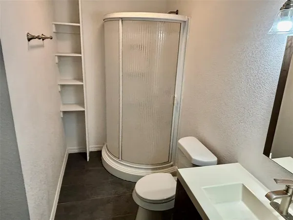 a white toilet sitting next to a shower