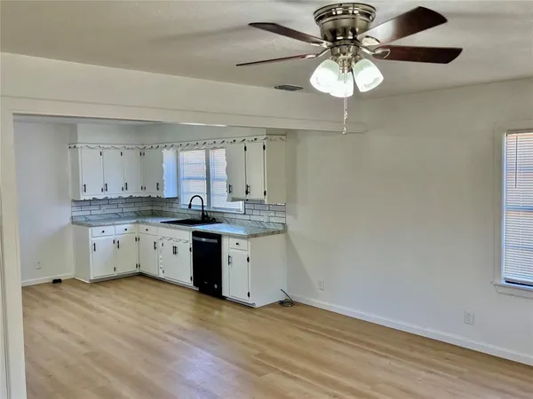 a kitchen with a sink cabinets and wooden floor