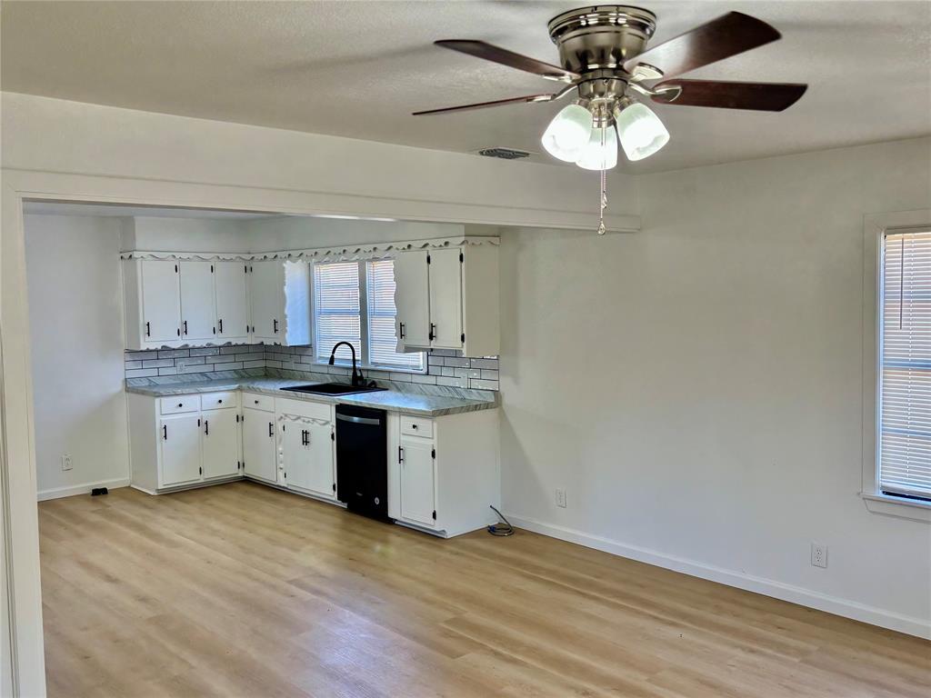 607 Baylor Street Nocona, TX 76255 - Photo 7 of 17 a kitchen with a sink cabinets and wooden floor