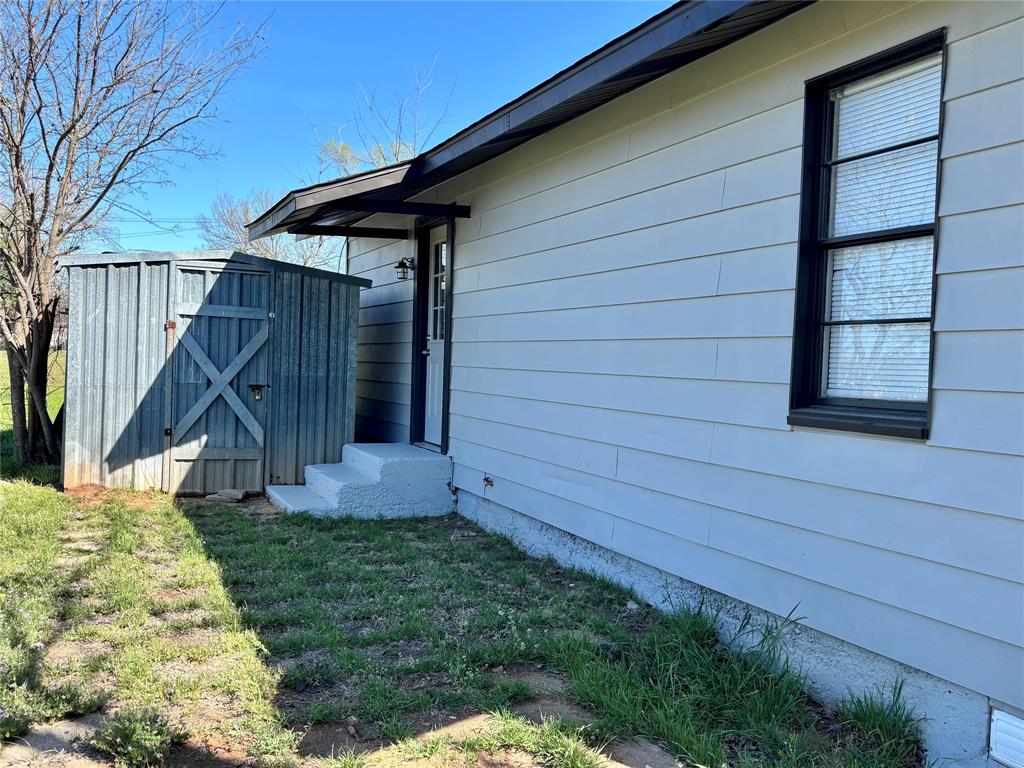 607 Baylor Street Nocona, TX 76255 - Photo 8 of 17 a view of a backyard with a small cabin