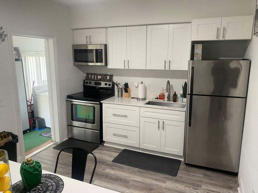 538 Southwest 7th Street Hallandale Beach, FL 33009 - Photo 16 of 35 a kitchen with stainless steel appliances a refrigerator stove microwave and sink