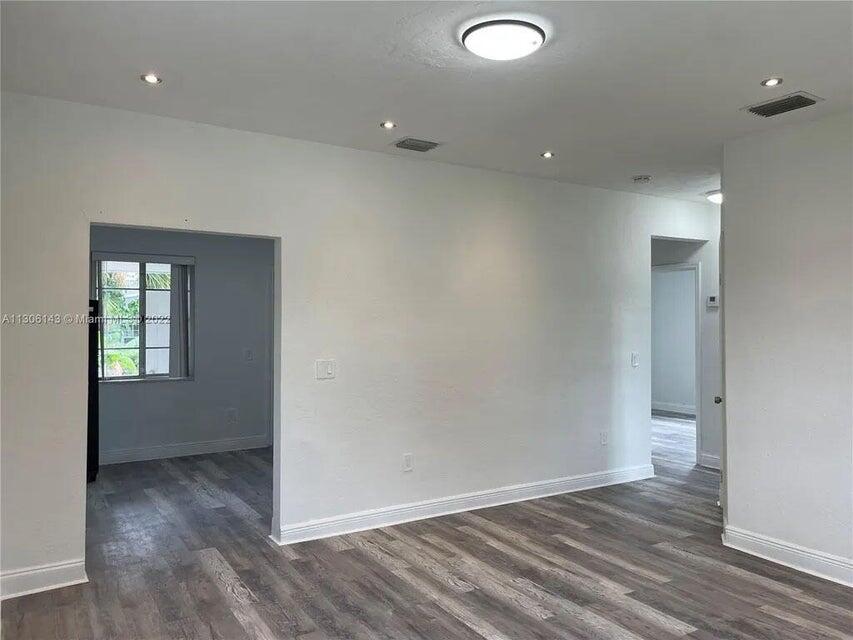 538 Southwest 7th Street Hallandale Beach, FL 33009 - Photo 17 of 35 an empty room with wooden floor and windows
