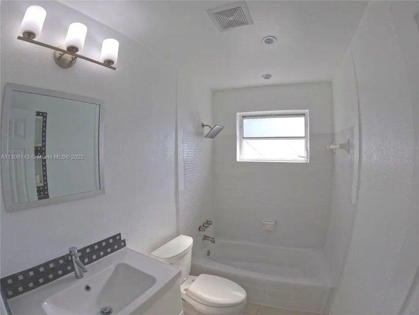 538 Southwest 7th Street Hallandale Beach, FL 33009 - Photo 27 of 35 a bathroom with a toilet a sink a mirror and a bathtub