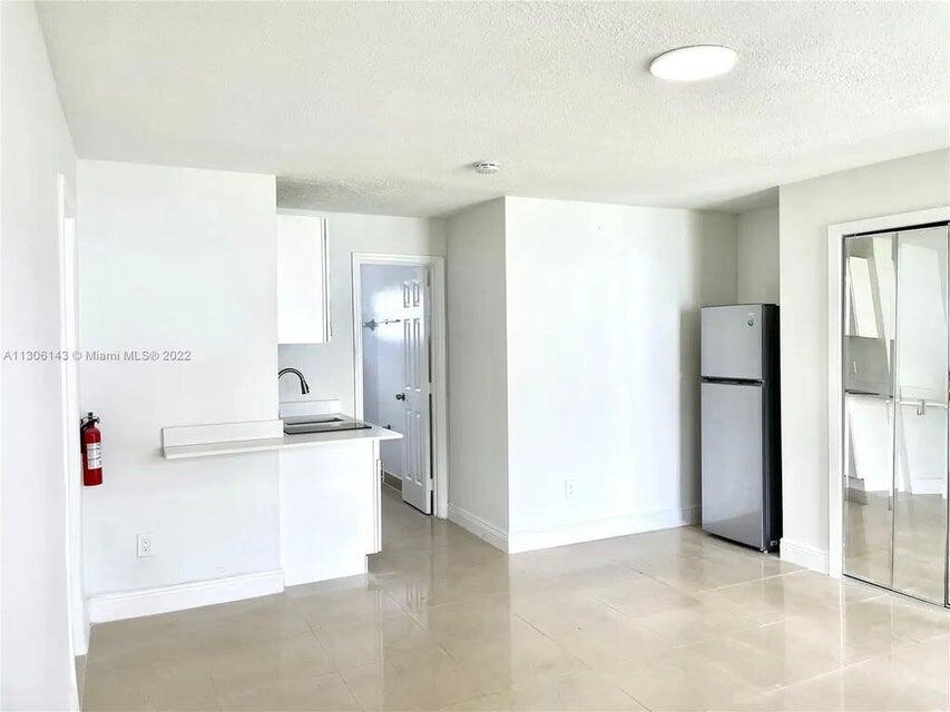 538 Southwest 7th Street Hallandale Beach, FL 33009 - Photo 31 of 35 a view of kitchen with refrigerator and white cabinets