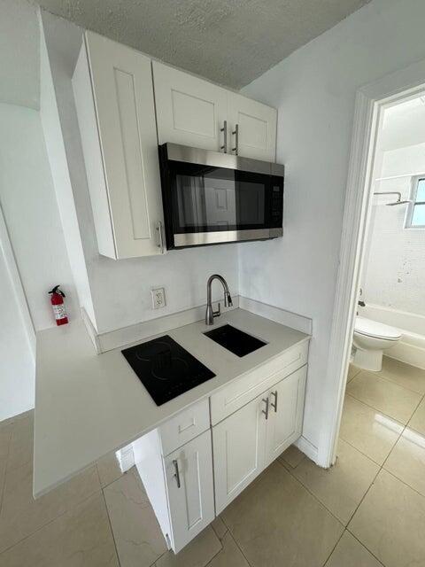 538 Southwest 7th Street Hallandale Beach, FL 33009 - Photo 32 of 35 a kitchen with a sink and white cabinets
