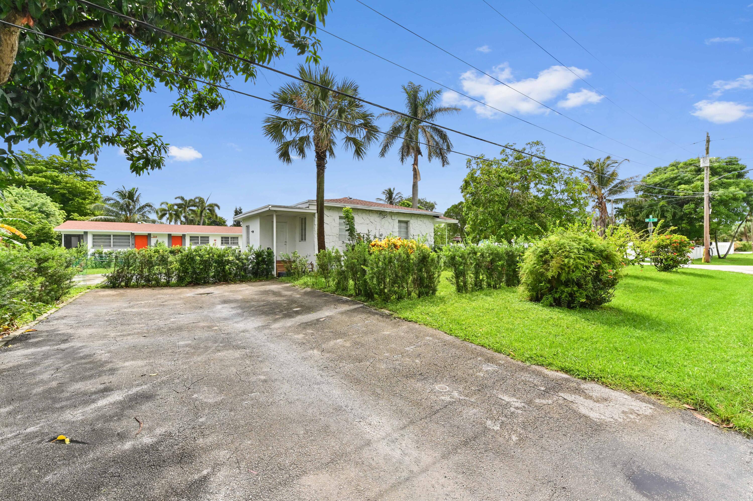 538 Southwest 7th Street Hallandale Beach, FL 33009 - Photo 7 of 35 a front view of a house with a yard and a garage