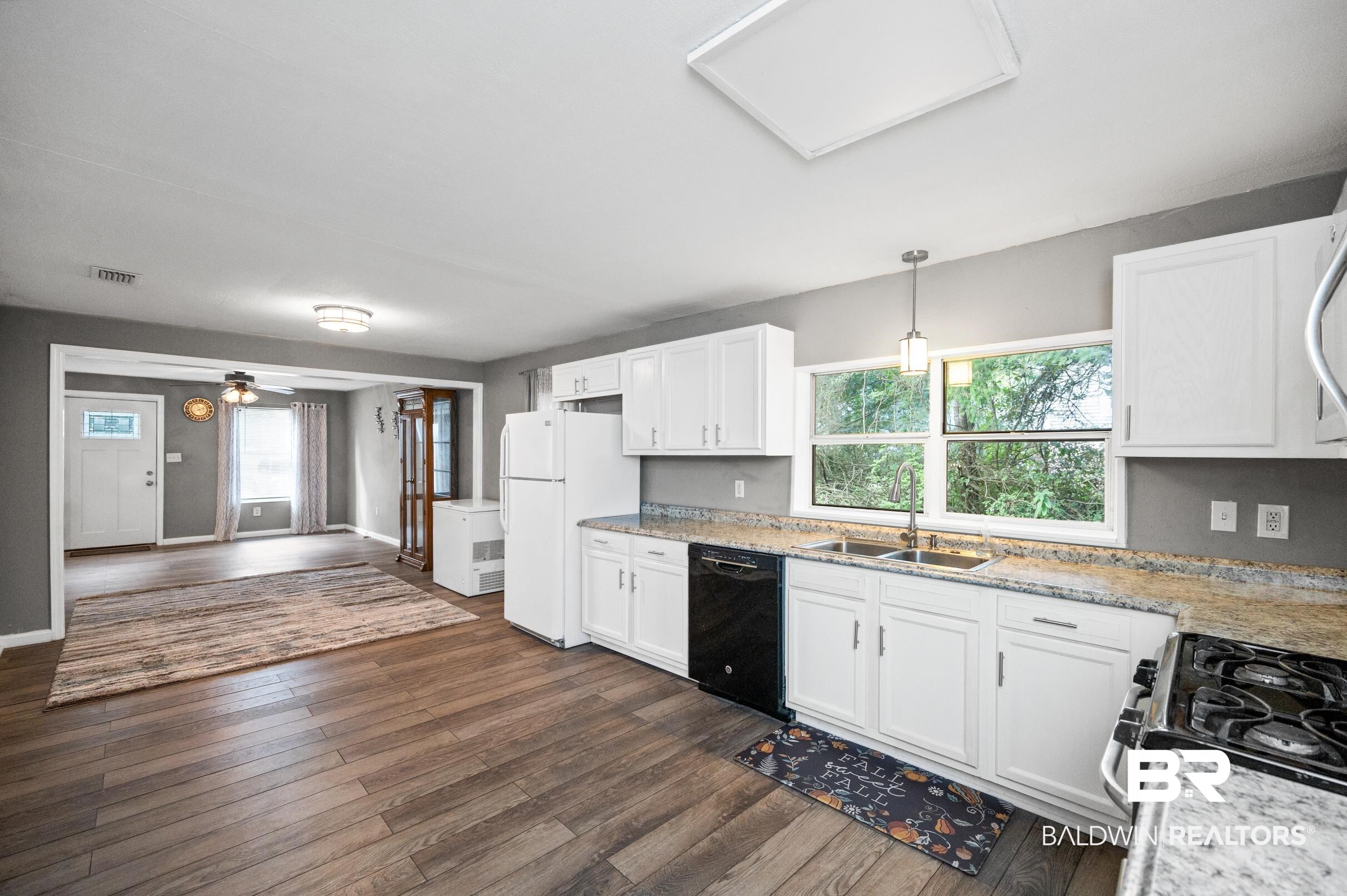906 North Cedar Street Foley, AL 36535 - Photo 7 of 24 Kitchen featuring white cabinets, dark hardwood / wood-style flooring, and black dishwasher