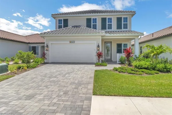 a front view of a house with a yard and a garage