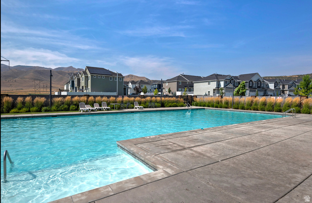 4887 Breezy Patch Road Eagle Mountain, UT 84005 - Photo 27 of 28 Community swimming pool featuring a large concrete deck, integrated steps, and stainless steel handrails