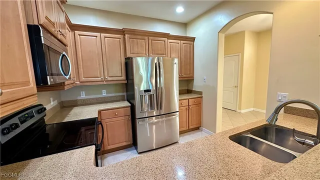 a kitchen with stainless steel appliances granite countertop a refrigerator and a sink