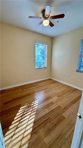 a view of an empty room and chandelier fan