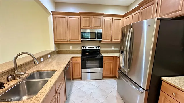 a kitchen with granite countertop a refrigerator and a sink