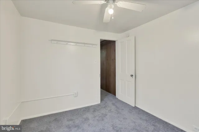 an empty room with a chandelier fan