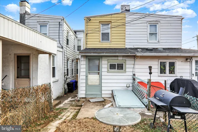 a backyard of a house with barbeque oven table and chairs