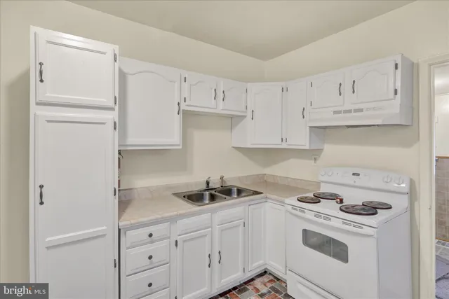 a kitchen with white cabinets and white appliances