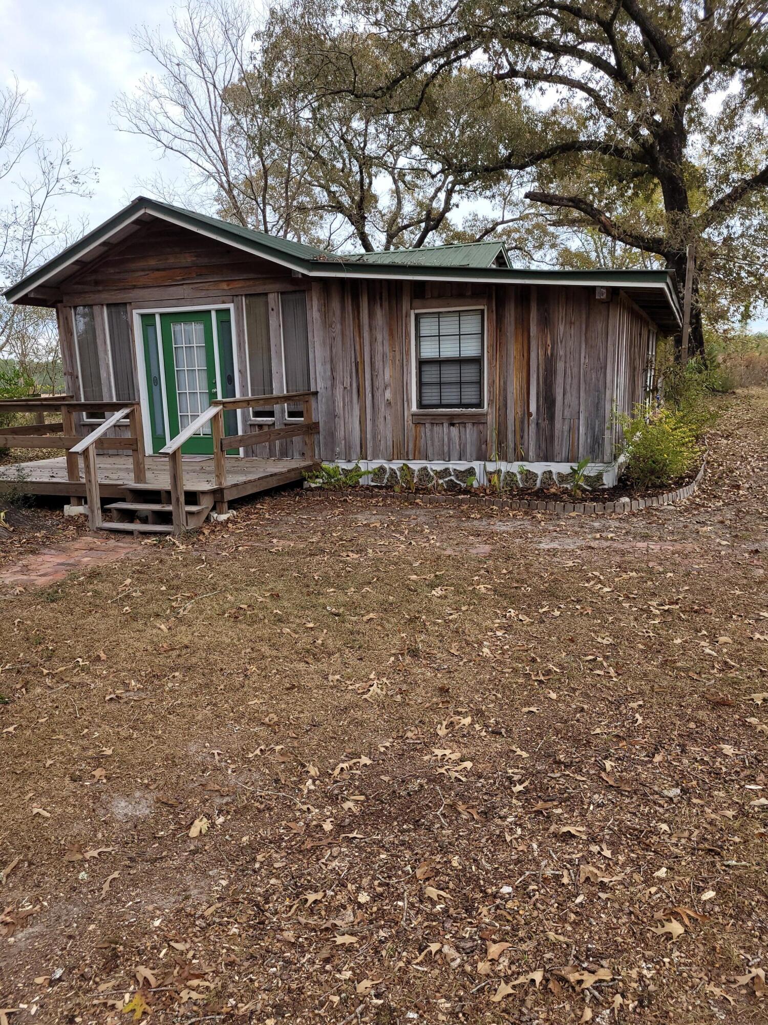 7363 Beaver Creek Road Baker, FL 32531 - Photo 26 of 29 a backyard of a house with barbeque oven and outdoor seating