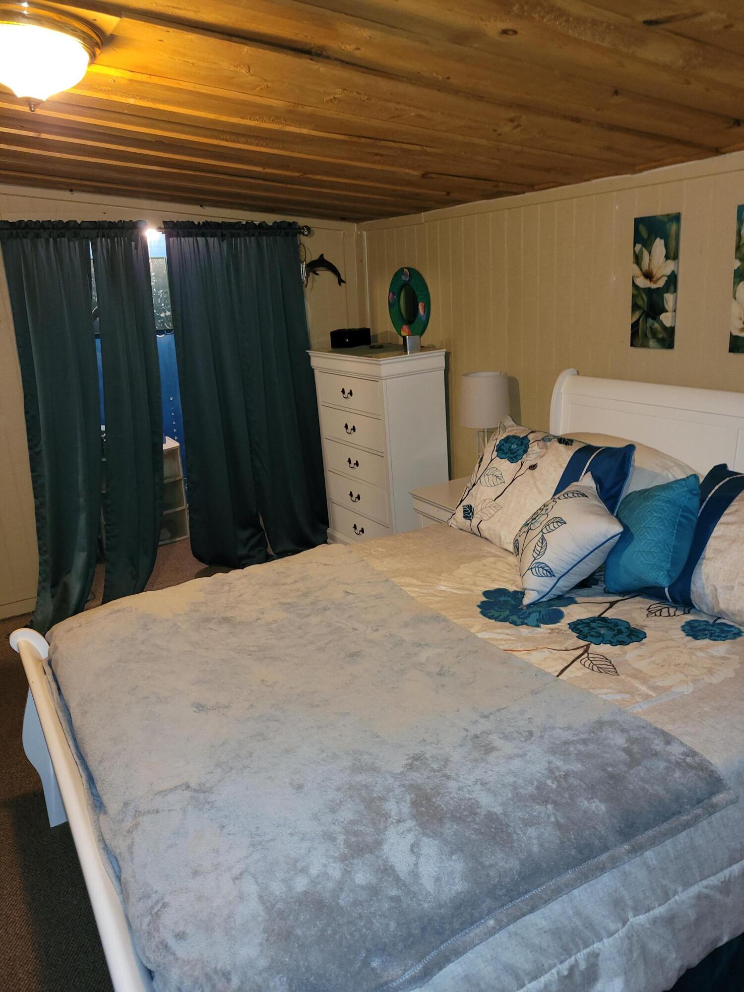 7363 Beaver Creek Road Baker, FL 32531 - Photo 5 of 29 a bedroom with a bed and wooden floor