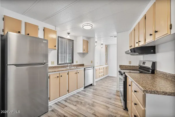 a kitchen with granite countertop a refrigerator stove top oven and sink
