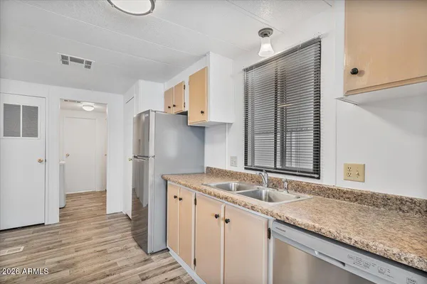 a kitchen with stainless steel appliances granite countertop a sink and a refrigerator