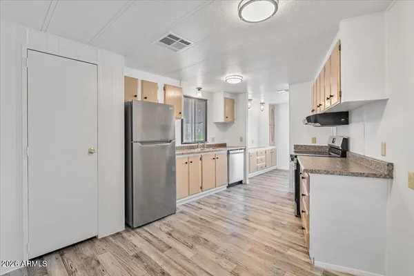 a kitchen with stainless steel appliances granite countertop a refrigerator a sink and a stove