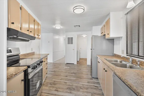 a kitchen with granite countertop a sink stainless steel appliances and cabinets