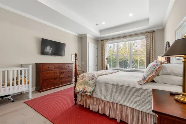 a bedroom with a bed a flat screen tv and a fireplace