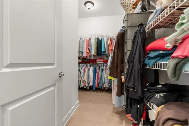 a view of walk in closet with clothes and shoes