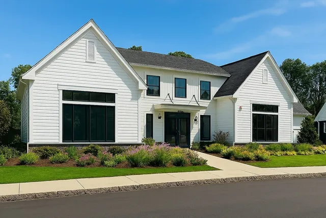 a front view of a house with a garden and plants