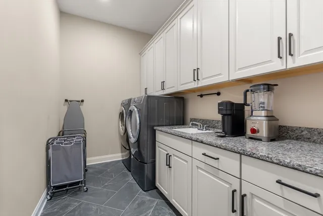 a kitchen with granite countertop cabinets and washer dryer