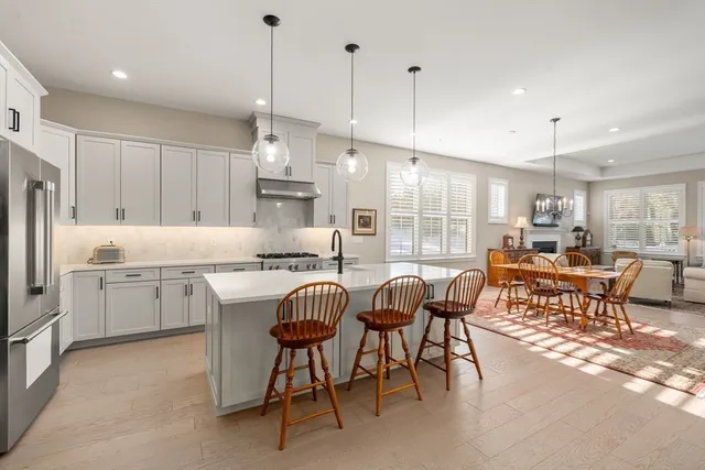 a kitchen with kitchen island a dining table chairs sink and cabinets