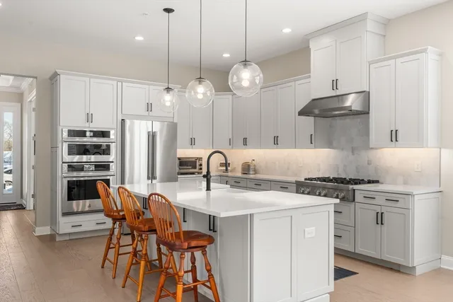 a kitchen with stainless steel appliances a stove a sink island and a refrigerator