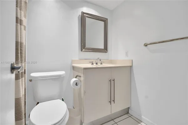 a bathroom with a toilet sink vanity and mirror