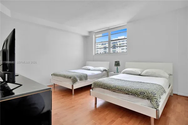 a bedroom with two beds and a flat screen tv