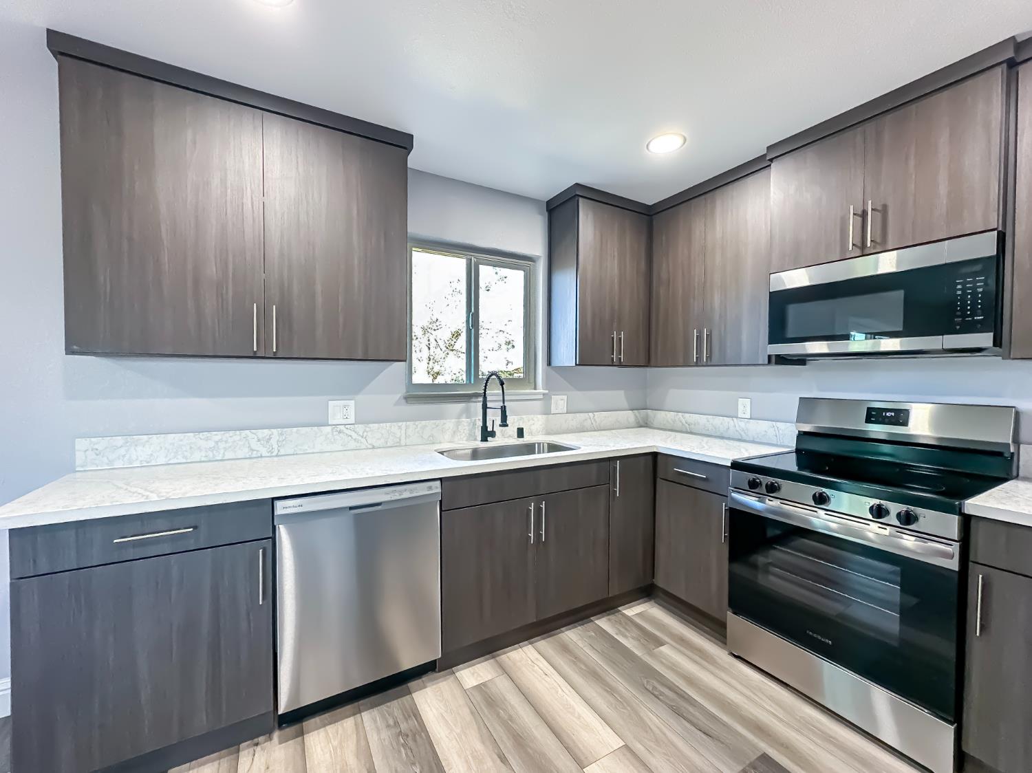 4804 Powerline Road Olivehurst, CA 95961 - Photo 28 of 65 a kitchen with stainless steel appliances granite countertop wooden cabinets a stove top oven a sink and dishwasher