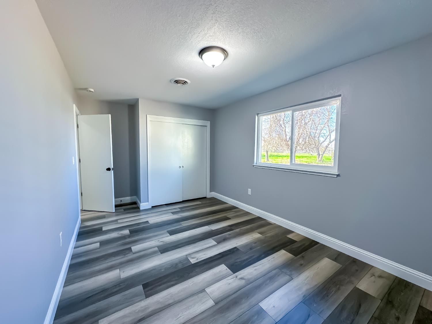 4804 Powerline Road Olivehurst, CA 95961 - Photo 39 of 65 a view of an empty room with wooden floor and a window