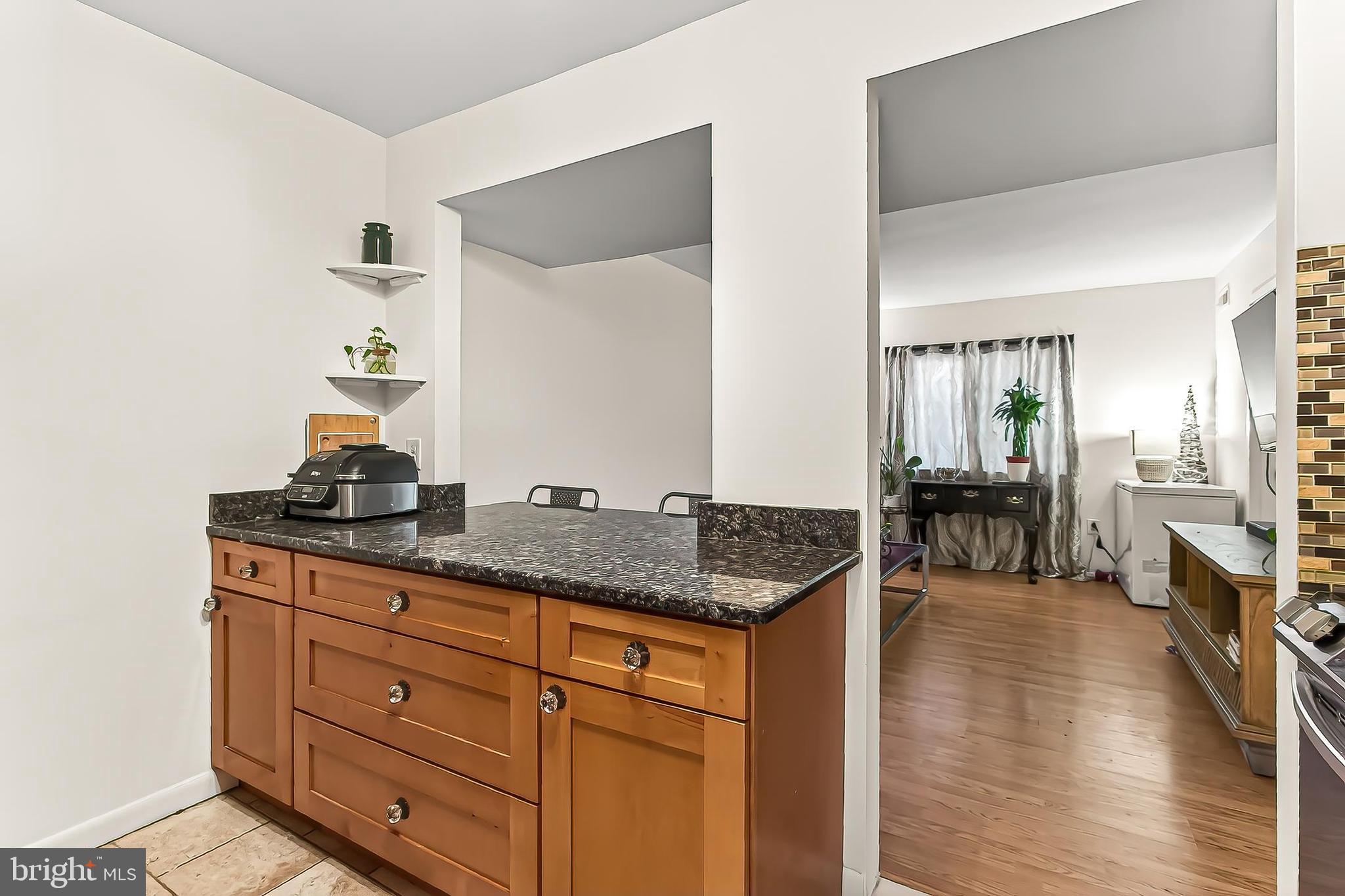 1809 Ivy Oak Square, Unit 61 Reston, VA 20190 - Photo 17 of 38 a kitchen with granite countertop a sink and a stove with wooden floor