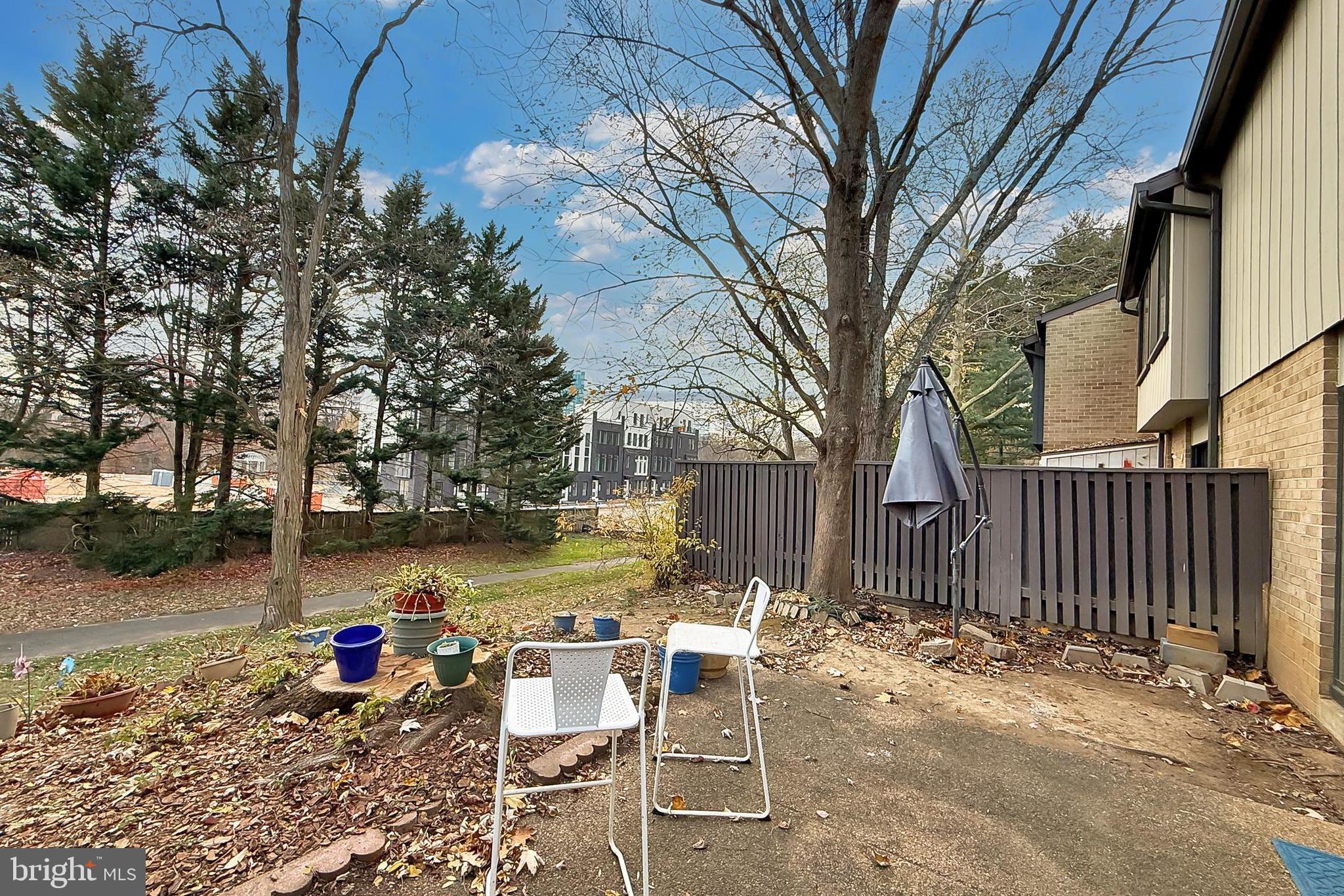 1809 Ivy Oak Square, Unit 61 Reston, VA 20190 - Photo 36 of 38 a view of a patio with a table and chairs under an umbrella with wooden fence