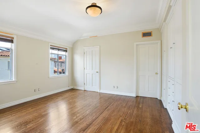 an empty room with windows and cabinet