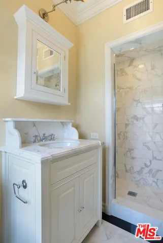 a bathroom with a granite countertop sink a vanity and a shower