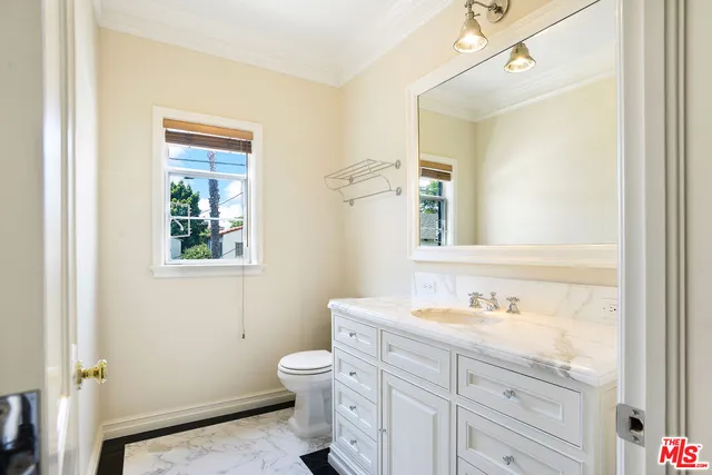 a bathroom with a sink a toilet and a mirror