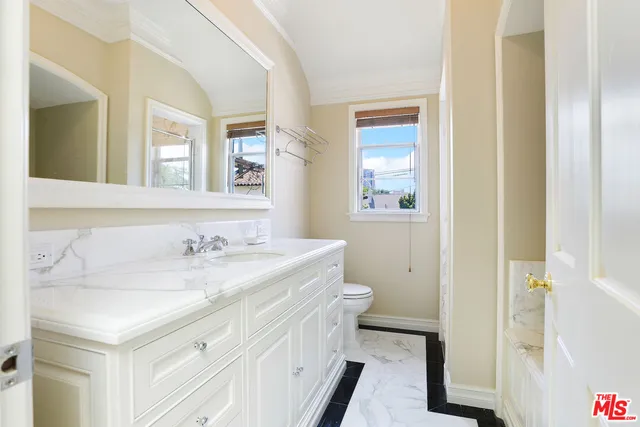 a bathroom with a sink a toilet and a mirror