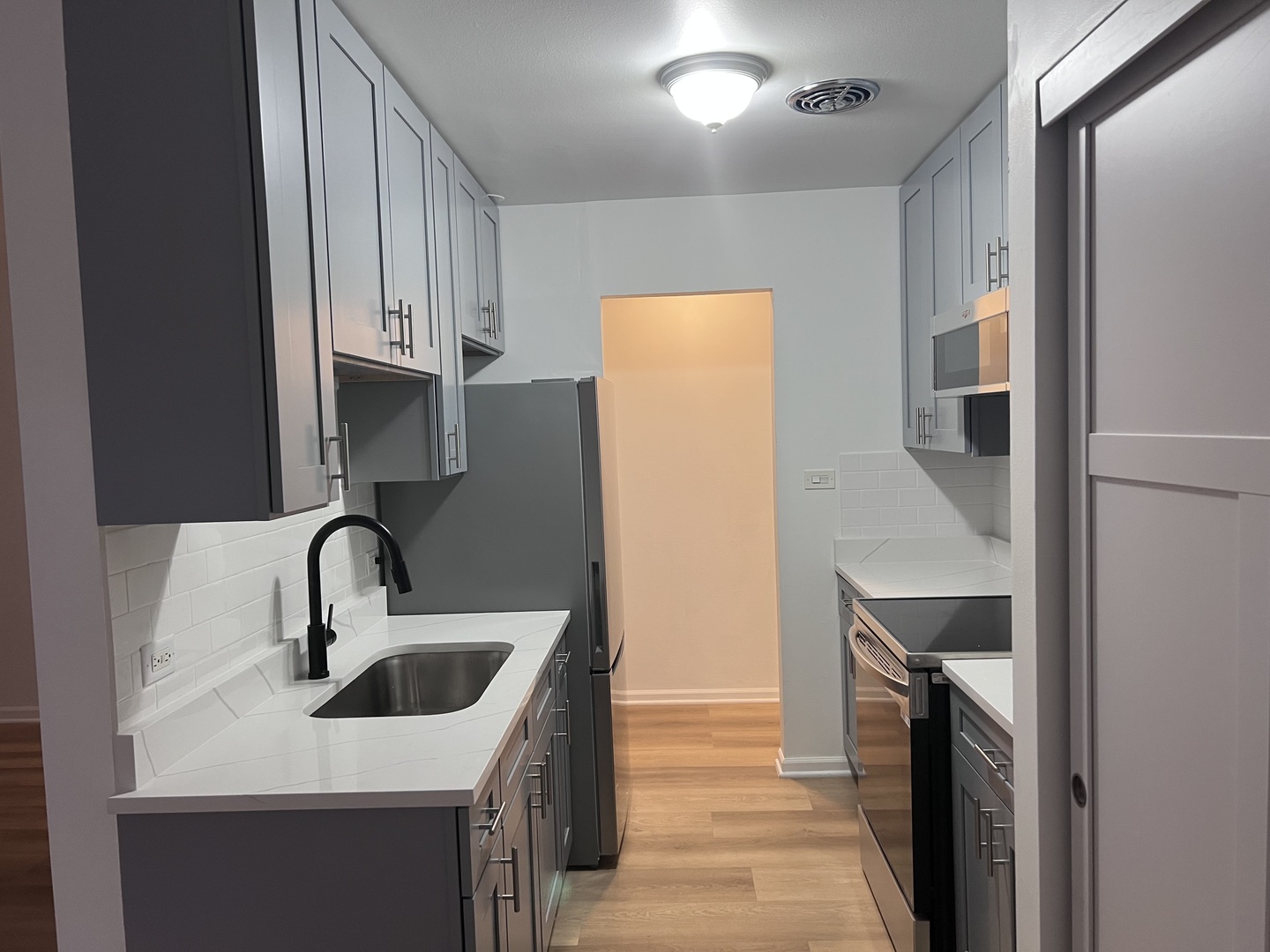 7120 North Sheridan Road, Unit 216 Chicago, IL 60626 - Photo 10 of 21 a kitchen with a sink and a refrigerator