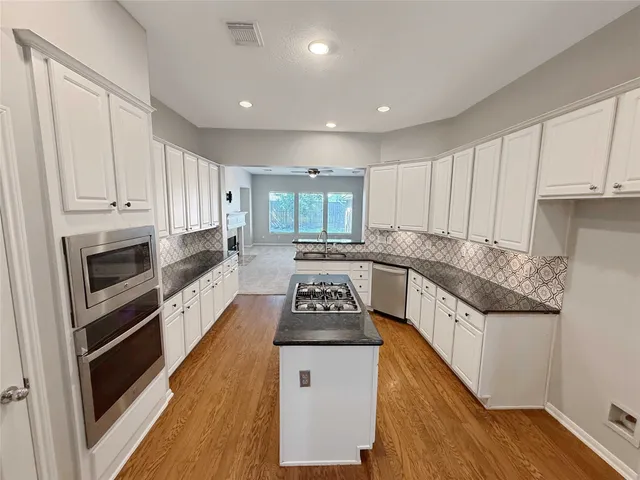 a kitchen with granite countertop a stove and a refrigerator