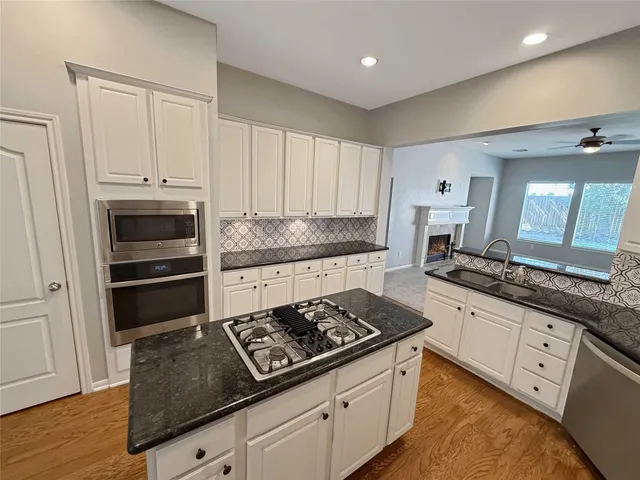 a kitchen with granite countertop a stove and a sink